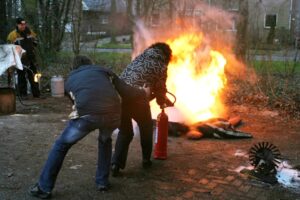 Employees practicing fire extinguisher use during a fire safety training session
