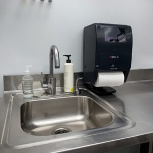 Commercial kitchen handwashing sink with soap and towel dispenser