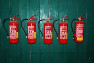 Different types of fire extinguishers showing color codes and classification labels