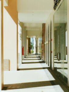 Fire extinguisher mounted on a wall in a commercial corridor with clear signage