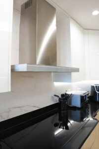 Modern commercial kitchen with stainless steel appliances and ventilation hoods