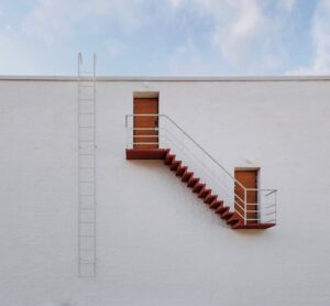 Commercial building fire drill with employees evacuating via stairwell.