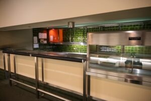 Modern commercial kitchen with stainless steel appliances and ventilation hoods