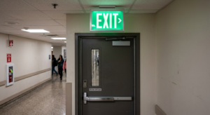 Illuminated emergency exit sign above a commercial door