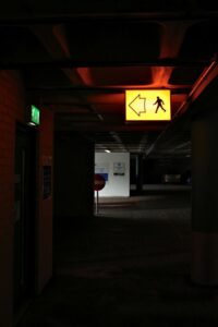 Dark commercial corridor with illuminated exit sign at the end
