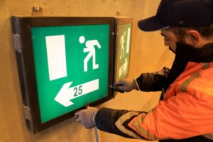 Technician testing an emergency light fixture