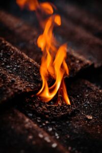 Close-up of a standard roof fire resistance test showing flames and embers.
