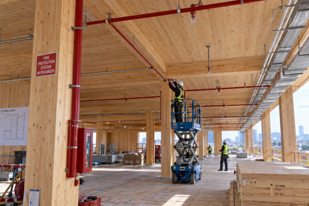 Mass timber building under construction showing exposed cross-laminated timber panels