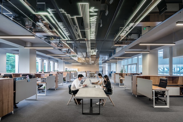 Modern open-plan office with natural light, plants, and collaborative workspaces